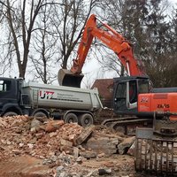 Schutt wird mit Bagger auf Transporter verladen